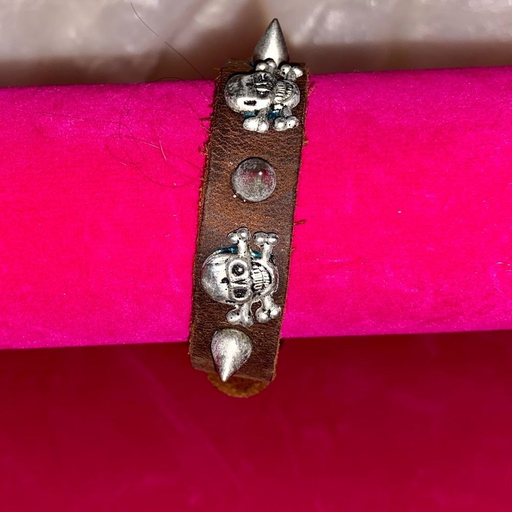 Vintage leather bracelet with metal skulls and spikes